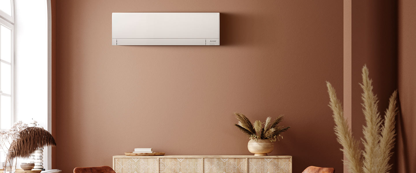 Climatiseur compact Mitsubishi Electric dans un salon aux couleurs terra cota